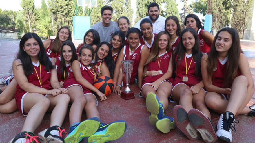 En una foto de grupo con sus entrenadores, Álvaro González y Javi Pérez, en mitad de una de las pistas de baloncesto del colegio.