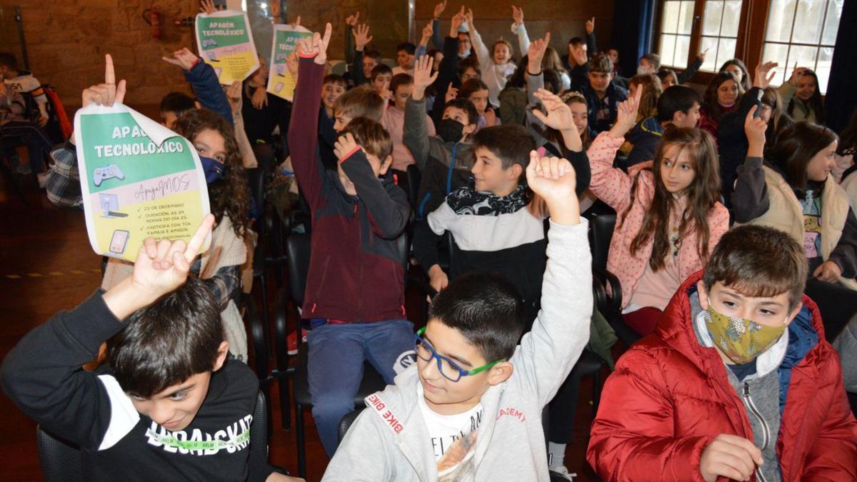 Alumnado asistente al pleno infantil levantan la mano a favor del apagón tecnológico.   | // D.P.