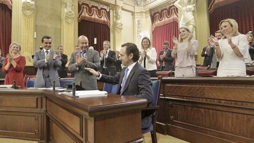 Los diputados del PP aplauden al presidente del Govern tras su discurso de ayer.