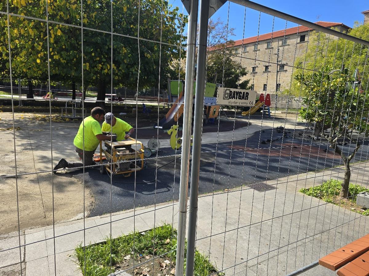 Dos de los operarios en el céntrico parque infantil, esta mañana.