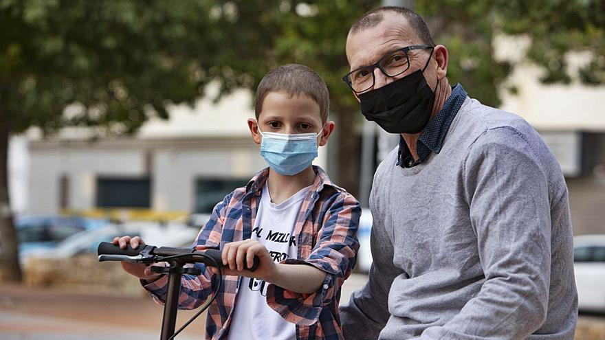Julio y Biel pasean con su patinete por un parque de Tavernes de la Valldigna, ayer. | PERALES IBORRA