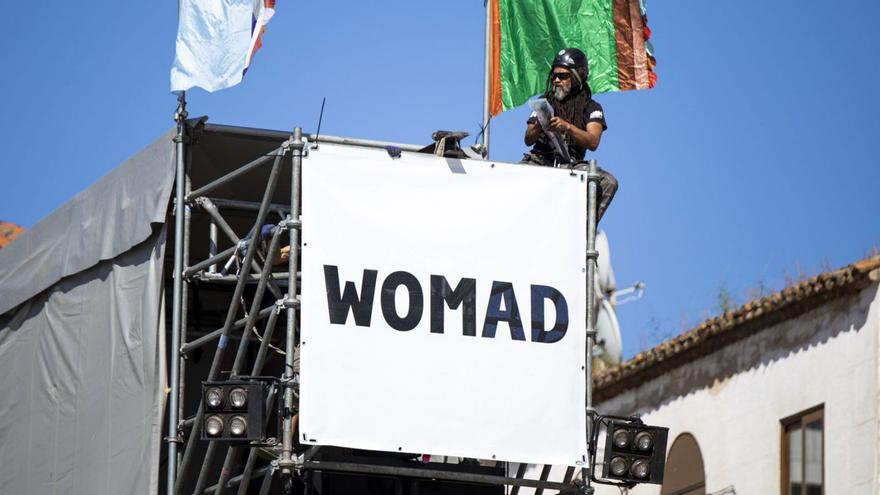 Operarios instalan el cartel de Womad, ayer en la plaza Mayor de Cáceres.