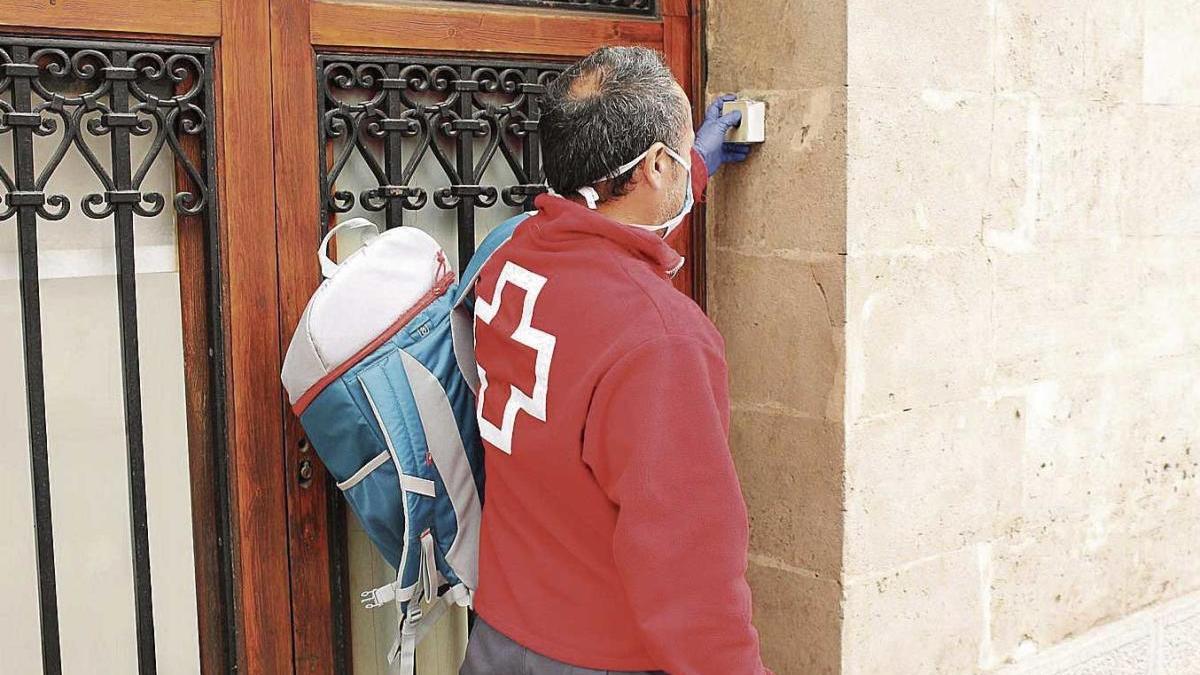 Un trabajador de la Cruz Roja lleva comida a domicilio a una vivienda de Palma.