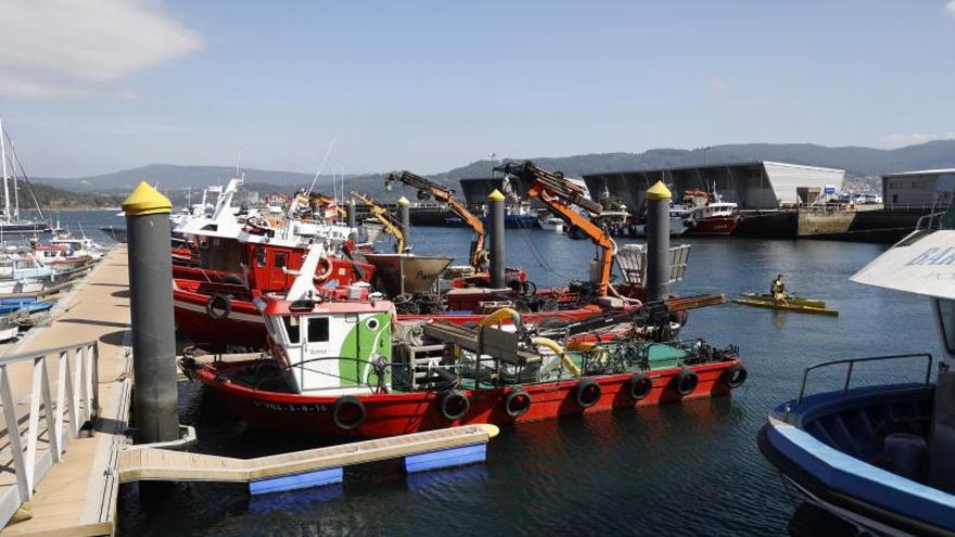 La embarcación que transporta la maquina que succiona algas en la ría, atracado en el puerto de Combarro. |   // GUSTAVO SANTOS