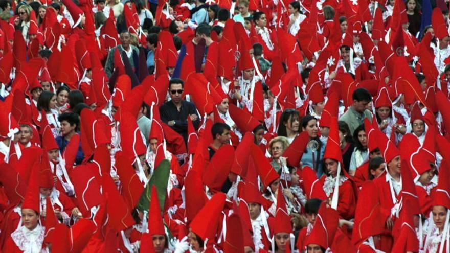 Miles de nazarenos participan en la procesión del Miércoles Santo por la tarde, que tiñe de rojo la capital murciana.