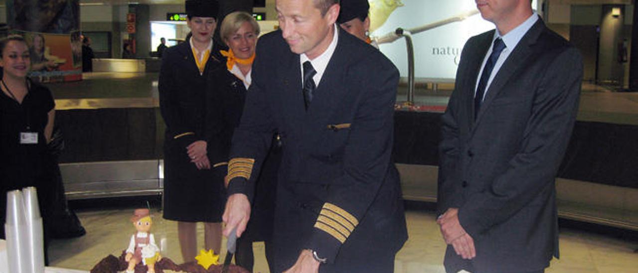 El piloto de la aeronave de Lufthansa corta la tarta, en el acto oficial.
