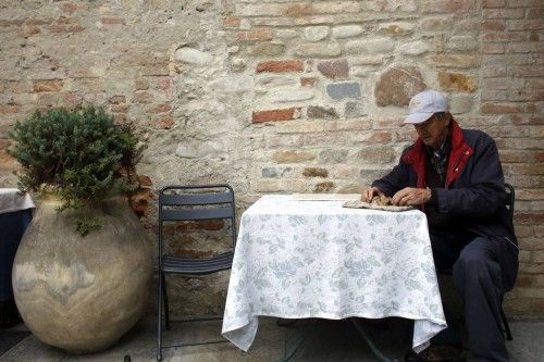 Costa inspects a truffle as he sits outside his restaurant in Monchiero near Alba northwestern Italy