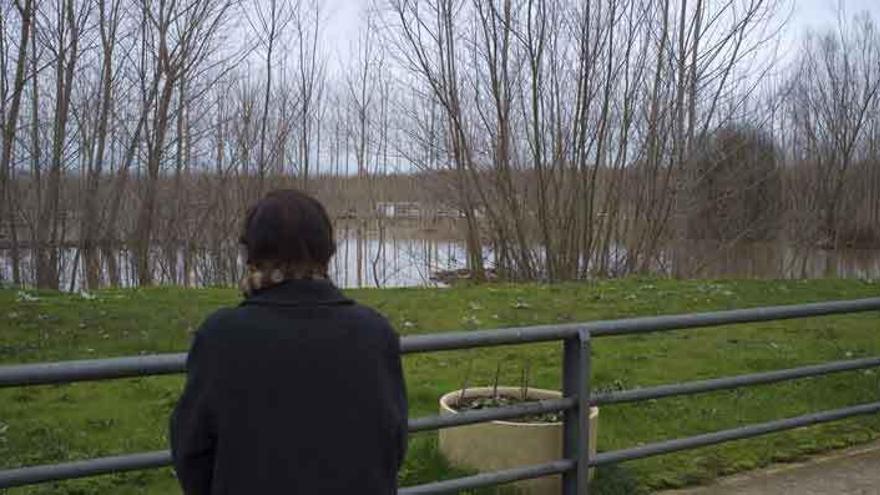 Una vecina de Arcos de la Polvorosa observa la crecida del río.