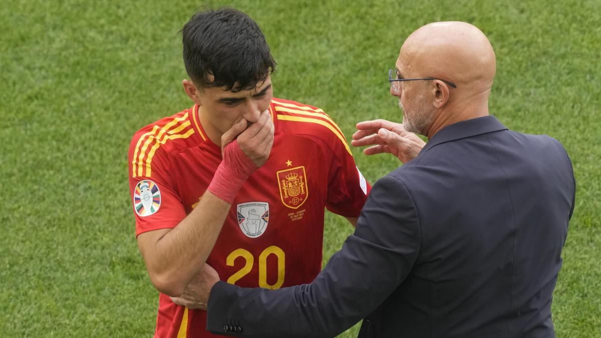 Pedri se retira lesionado durante el partido ante Alemania, consolado por Luis de la Fuente.