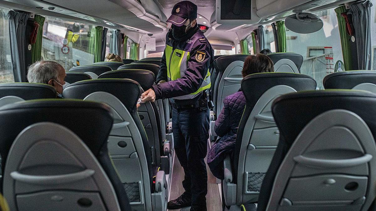 Un agente de la Unidad de Fronteras inspecciona en la frontera de San Martín del Pedroso un autobús de la ruta Oporto-París. | Emilio Fraile