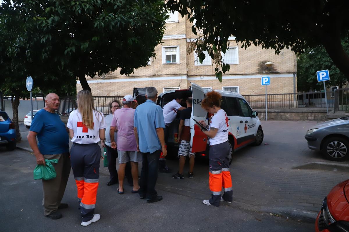Voluntarios de Cruz Roja reparten vasos de gazpacho a personas sin techo, este martes, en Córdoba.