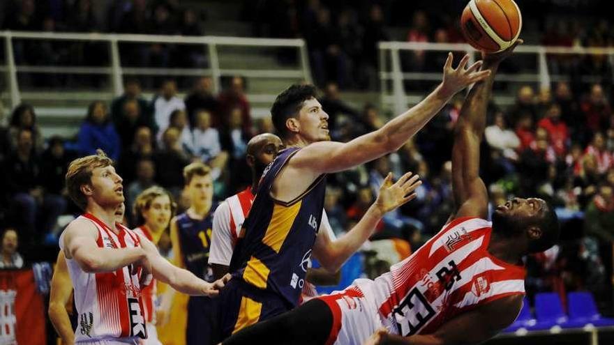 Felipe Braga trata de hacerse con el balón ante Ryan Ejim, que está cayéndose.