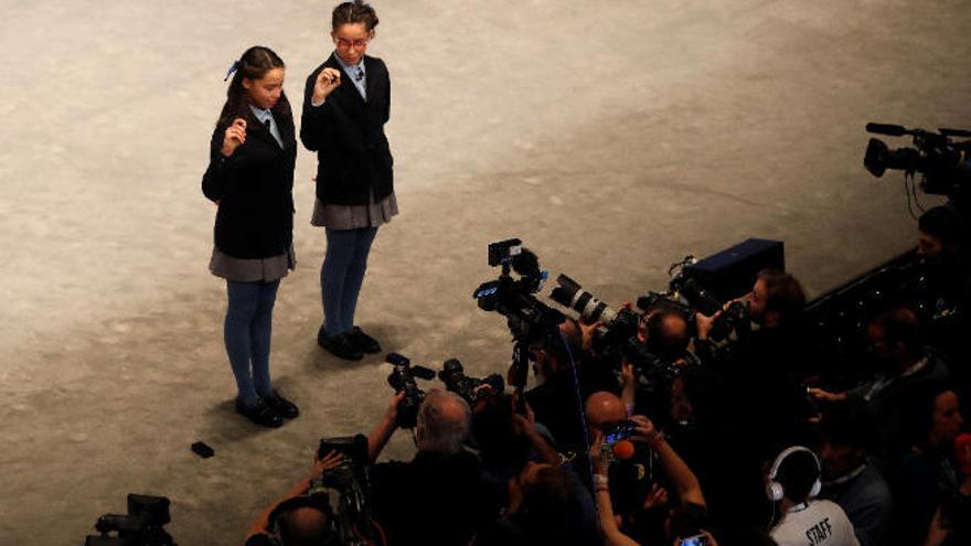 Las niñas de San Ildefonso Noura Akrouh y Elisabeth del Carmen Roque cantan ante el público y los medios el premio Gordo de la Lotería de Navidad.