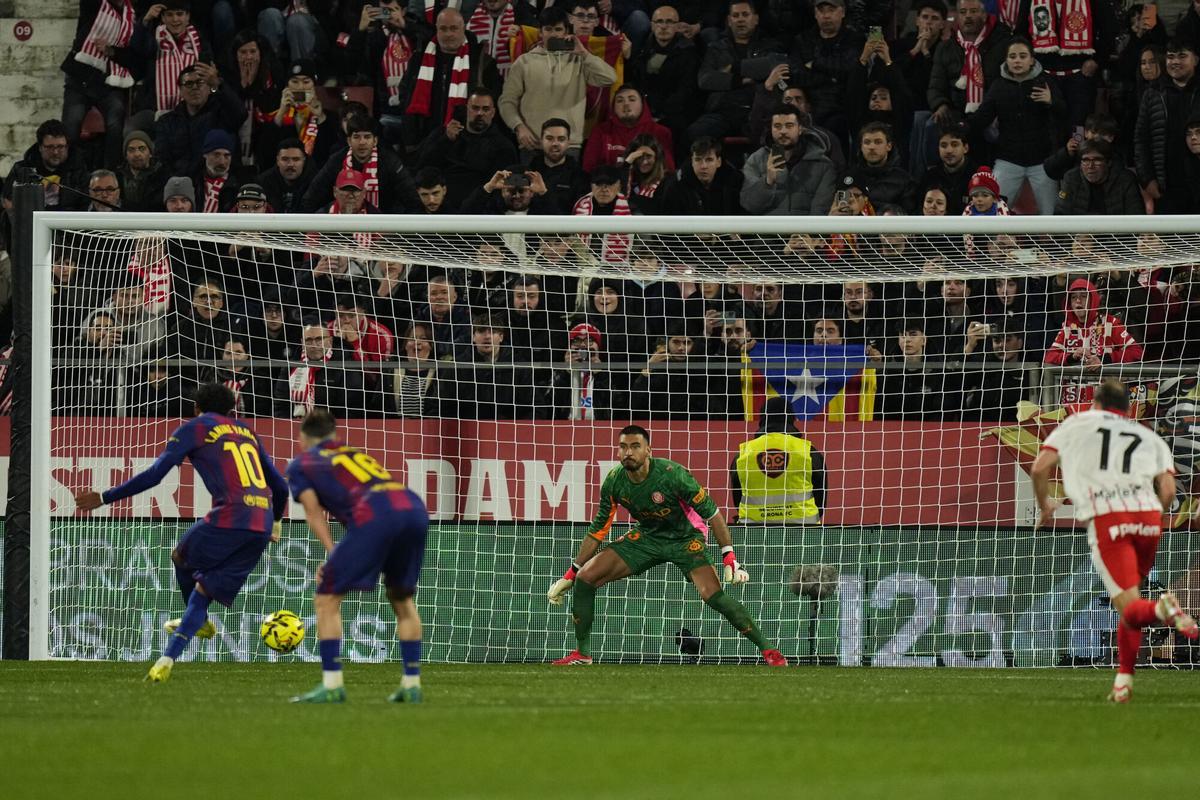 El delantero del FC Barcelona, Lamine Yamal (i), lanza un penalti frente al guardameta argentino del Girona, Paulo Gazzaniga, durante el partido de LaLiga de fútbol que Girona FC y FC Barcelona disputan este lunes en el estadio de Moltilivi. EFE/Siu Wu
