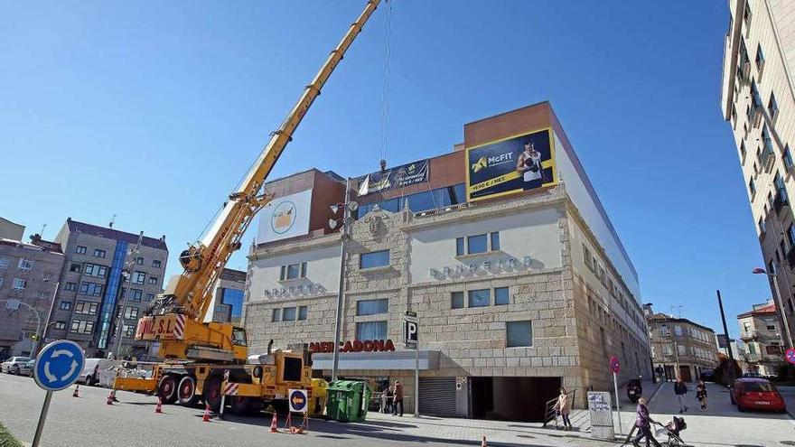 Una grúa, ayer por la mañana, trabajando en el Centro Comercial Bandeira. // Marta G. Brea