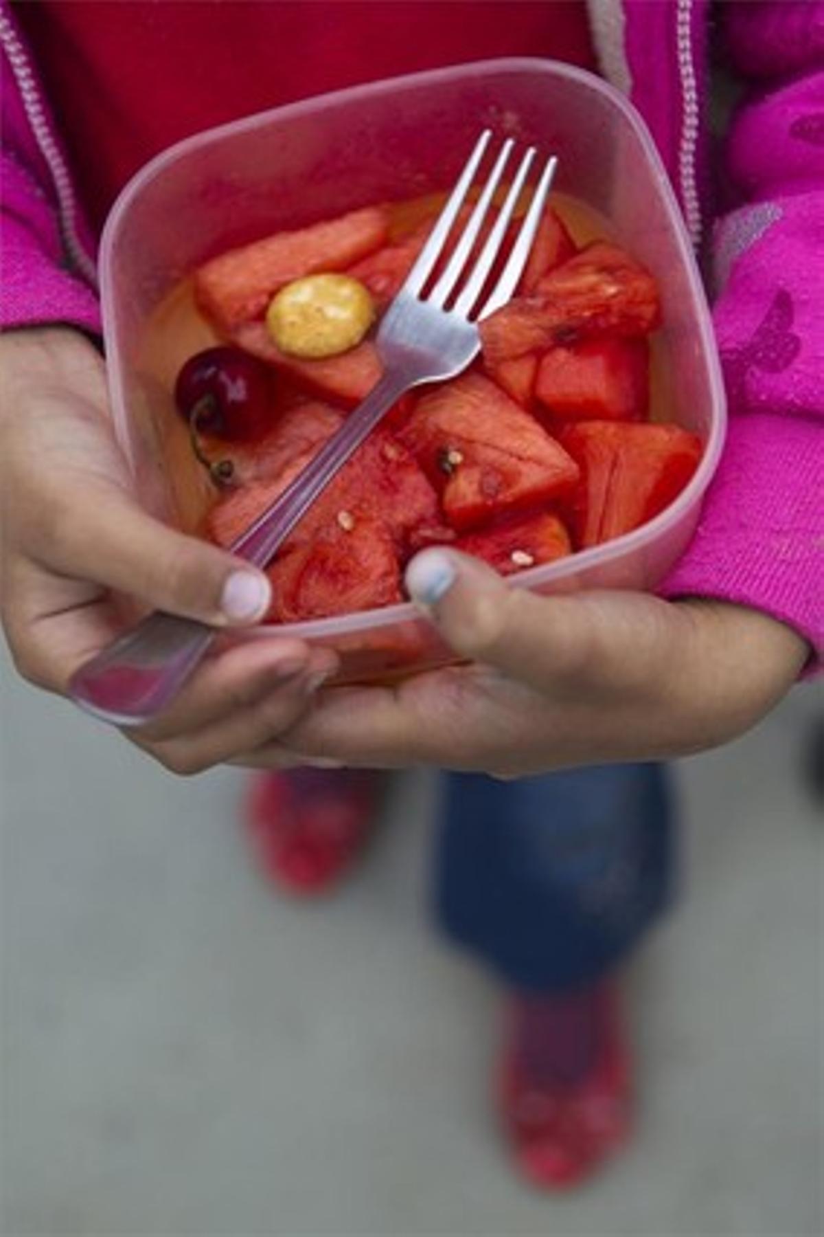 Un niño sostiene un plato de sandía