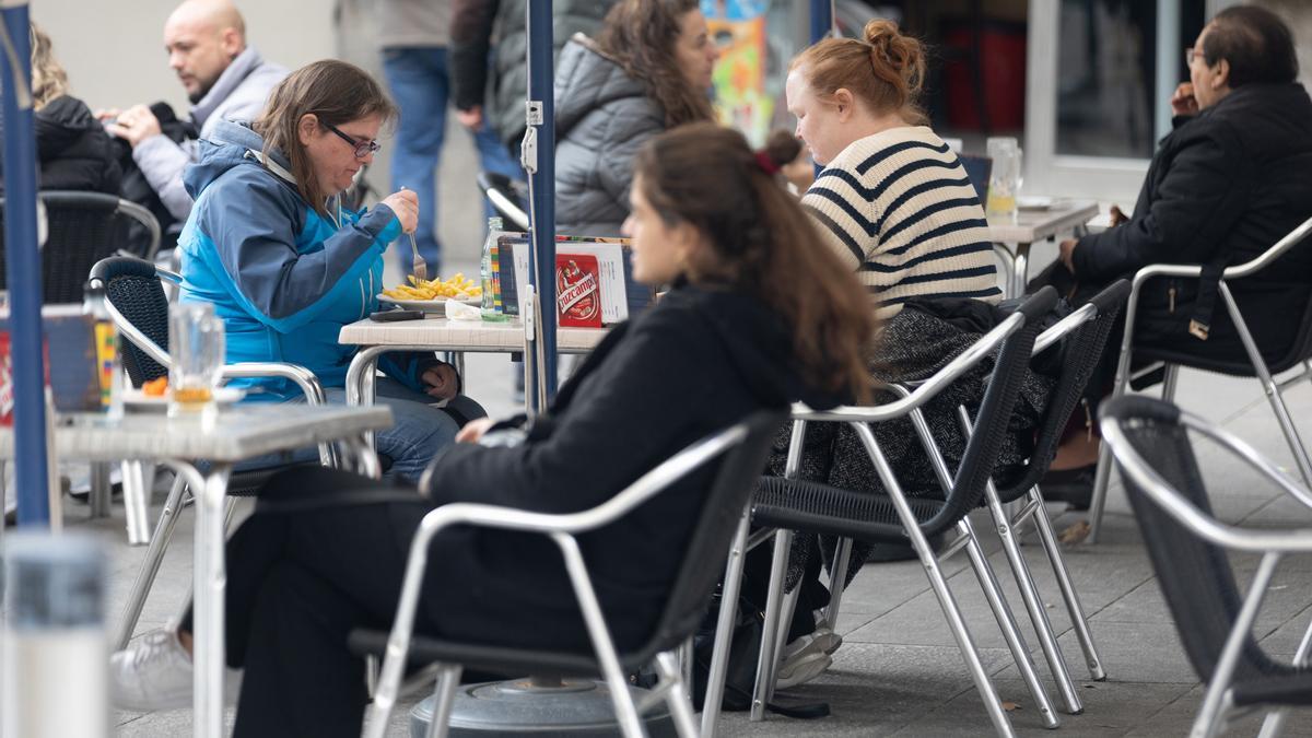 Varias personas en la terraza de una bar.