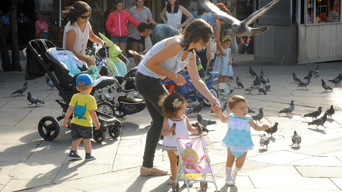 GENTE PASEANDO POR UNA CALLE DE PONTEVEDRA / POBLACION. NIÑOS. CARRITOS DE BEBE. NATALIDAD. GALICIA