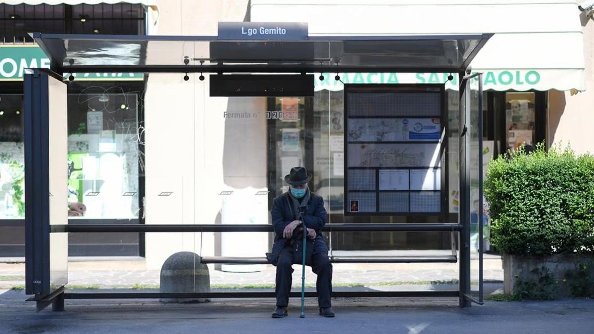 Un hombre en una parada de autobús de Milán.