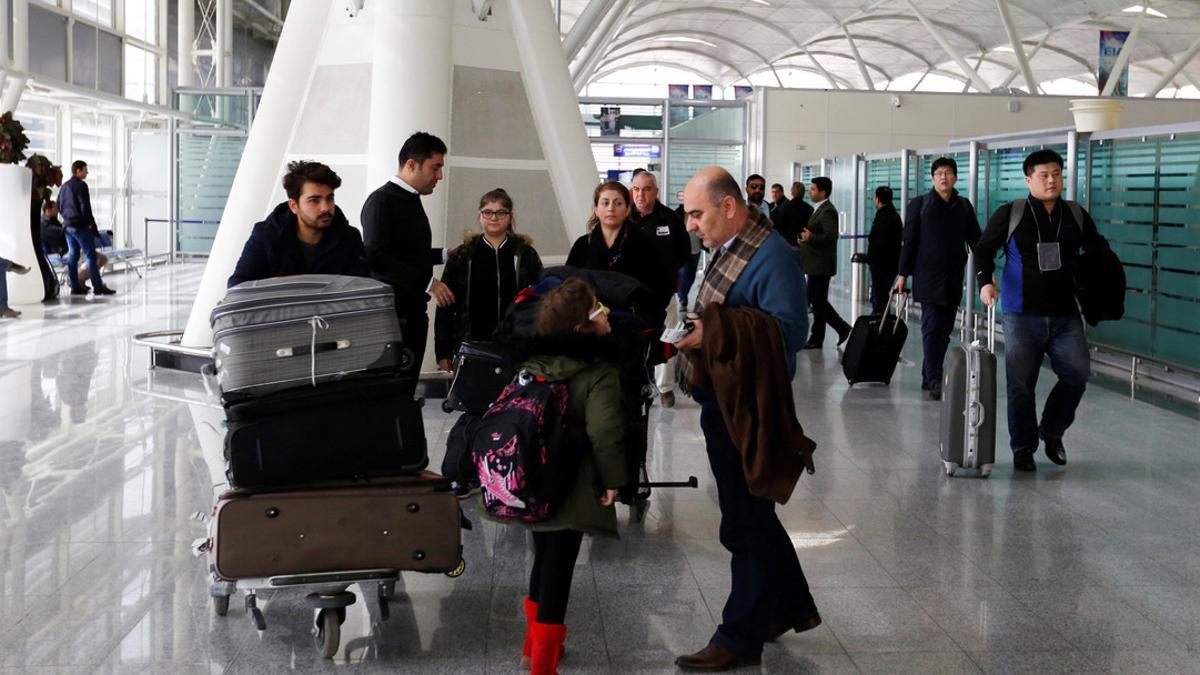 Fuad Sharef Suleman and his family push their belongings after returning to Iraq after they were prevented from boarding a plane to the U.S., following U.S. President Donald Trump's decision to temporarily bar travellers from Iraq