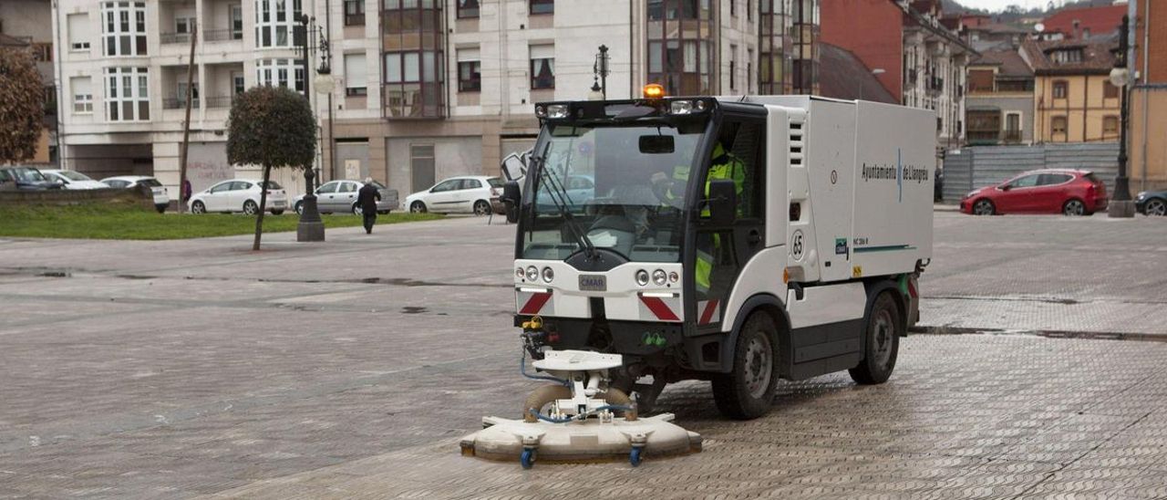 Una máquina limpiando aceras en Langreo.