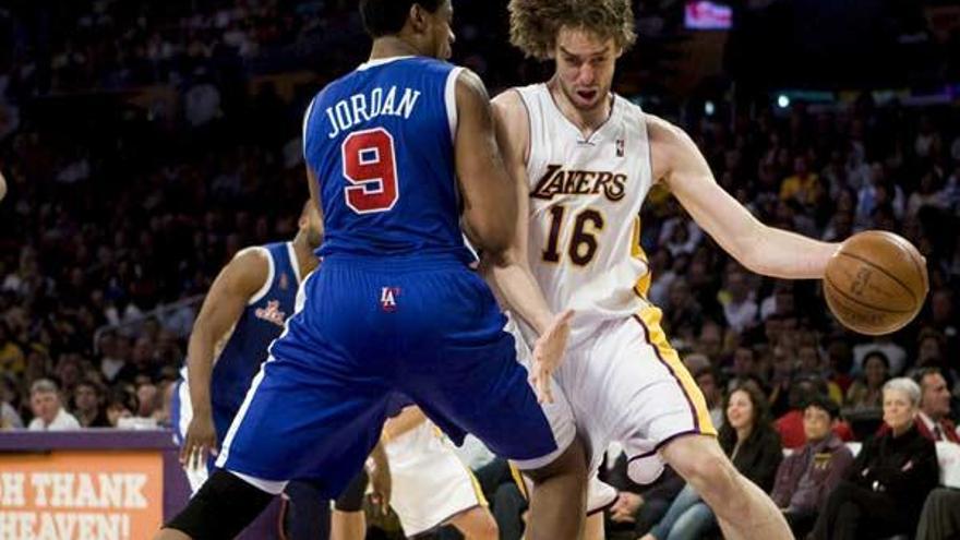 El pívot de los Los Angeles Lakers Pau Gasol conduce la pelota ante la oposición del pívot de Los Angeles Clippers DeAndre Jordan