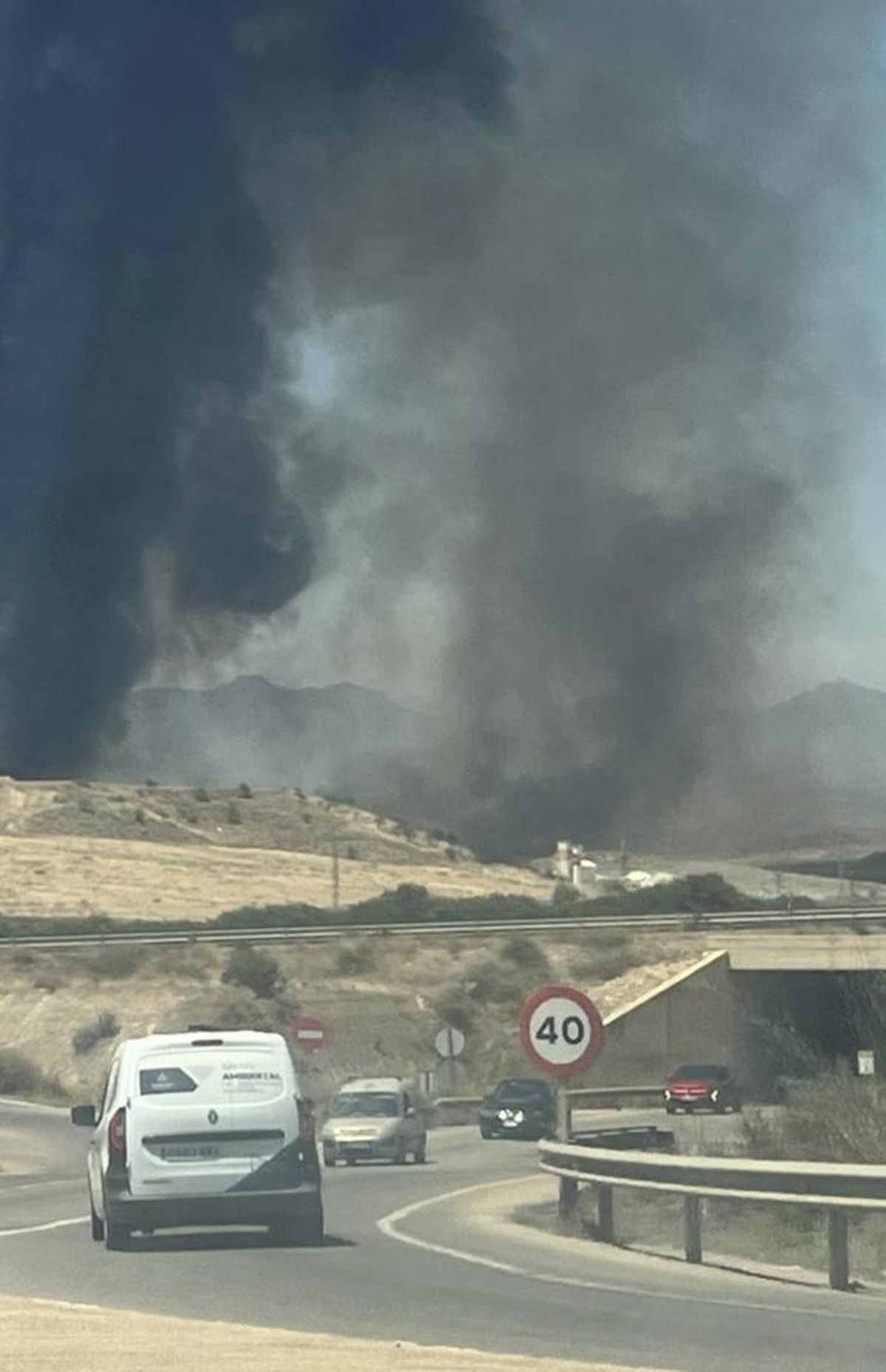 Vehículos se dan la vuelta en una carretera debido a la proximidad del incendio, este jueves en Mazarrón.