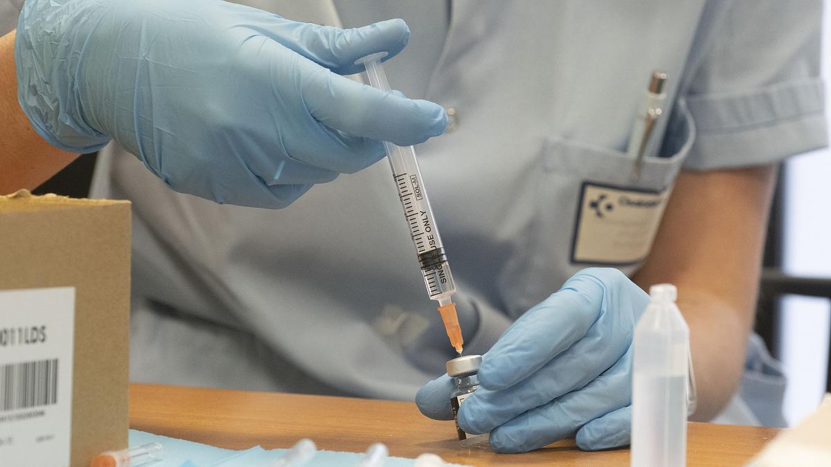 Un sanitario prepara una vacuna contra el COVID.