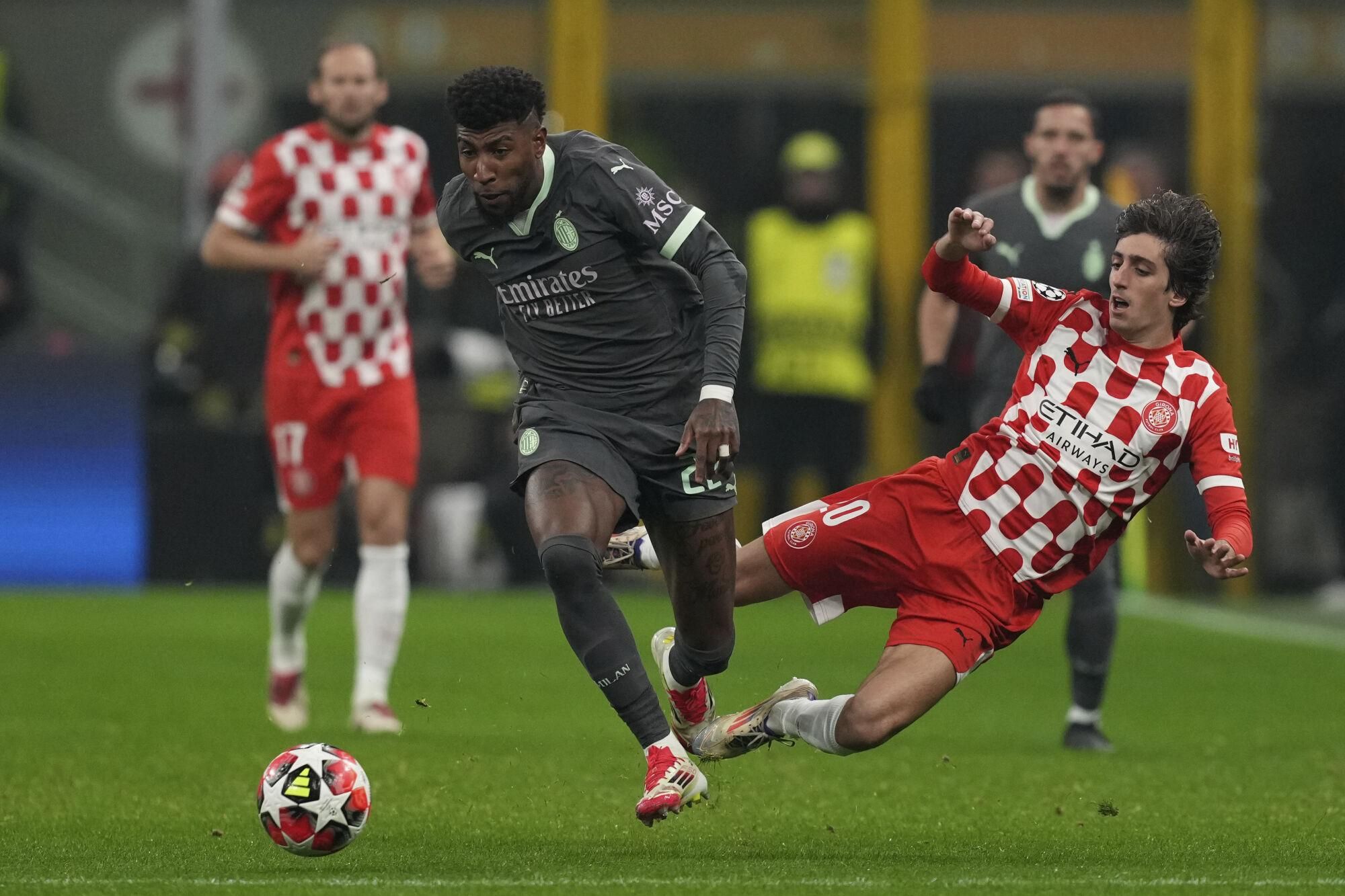 AC Milan's Emerson Royal, left is tackled by Girona's Bryan Gil during the Champions League opening phase soccer match between AC Milan and Girona at the San Siro stadium in Milan, Italy, Wednesday, Jan. 22, 2025. (AP Photo/Antonio Calanni)