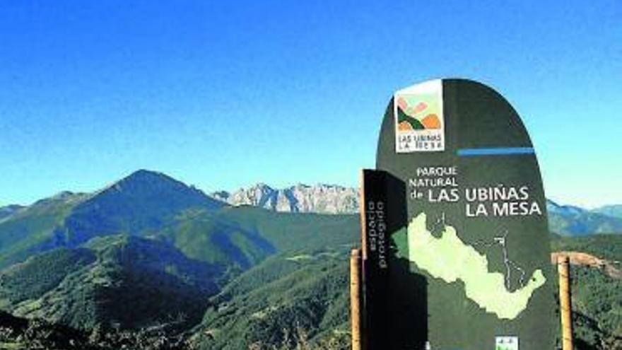 Cartel del parque natural de Las Ubiñas-La Mesa, con los montes al fondo.
