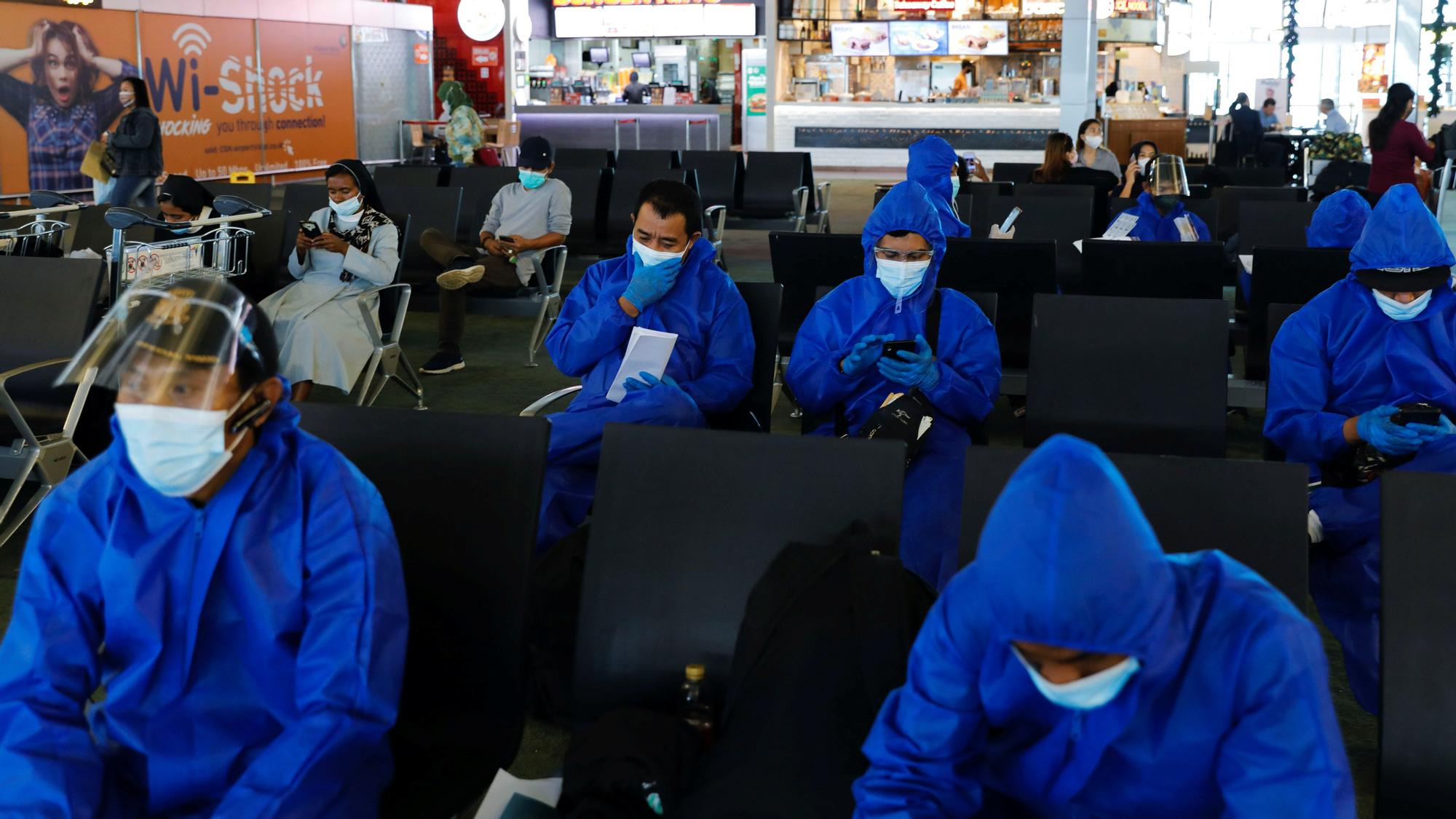 COVID-19 protocols tightened to curb the spread of Omnicron variant of the coronavirus in Tangerang Travellers wearing protective suits are seen at the Soekarno Hatta International airport, as the country bans the arrival of travellers who have been in eight African countries to curb the spread of the new Omicron variant of the coronavirus, in Tangerang, near Jakarta, Indonesia, November 29, 2021. REUTERS/Willy Kurniawan