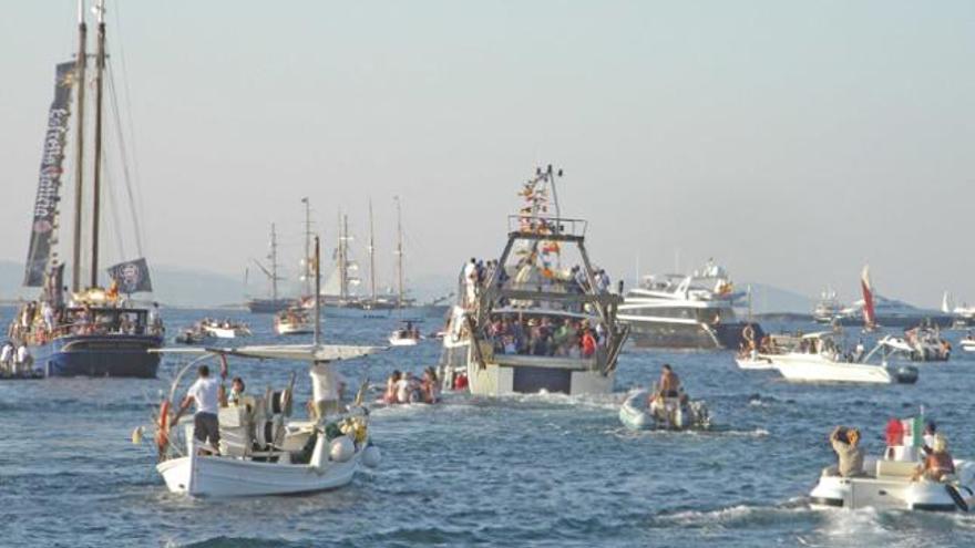 Los arrastreros locales, uno de ellos el ´Punta Ponent´, con la imagen de la Virgen del Carmen a bordo, y decenas de embarcaciones que la siguen.