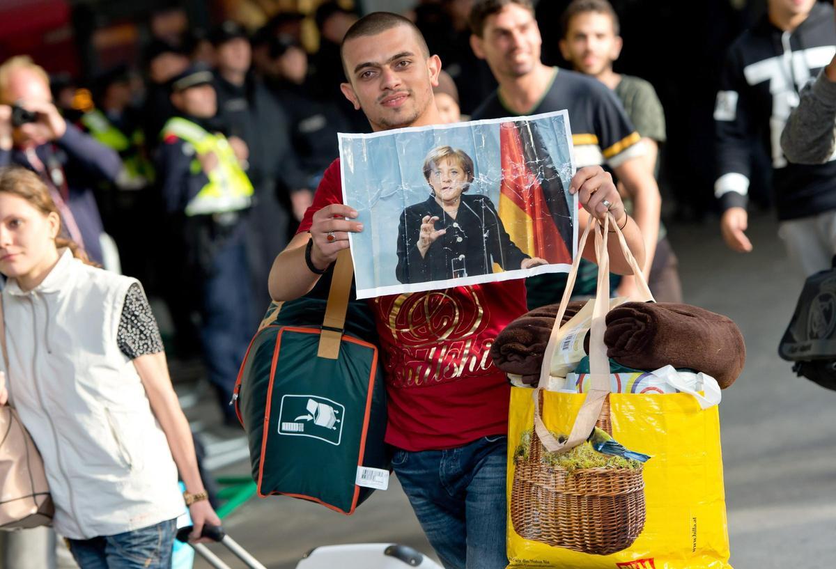Un refugiadomuestra una fotografía de Angela Merkel a su llegada a la estación de tren de Múnic, el 5 de septiembre de 2015.