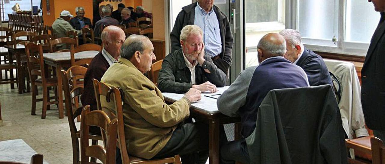 Jubilados juegan a las cartas en un centro de mayores.