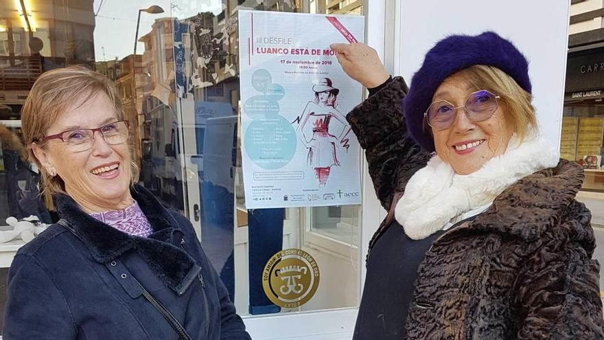 Josefina Fernández y Rosa Somoano posan con el cartel del desfile.