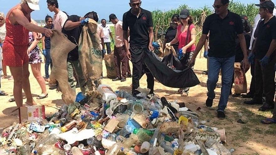 Voluntarios de la compañía hotelera limpian una playa