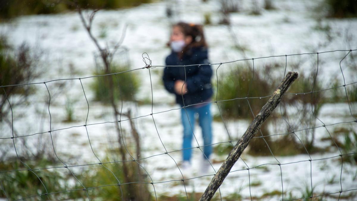 Una niña juega con las nieve en las proximidades del embalse de Cúber