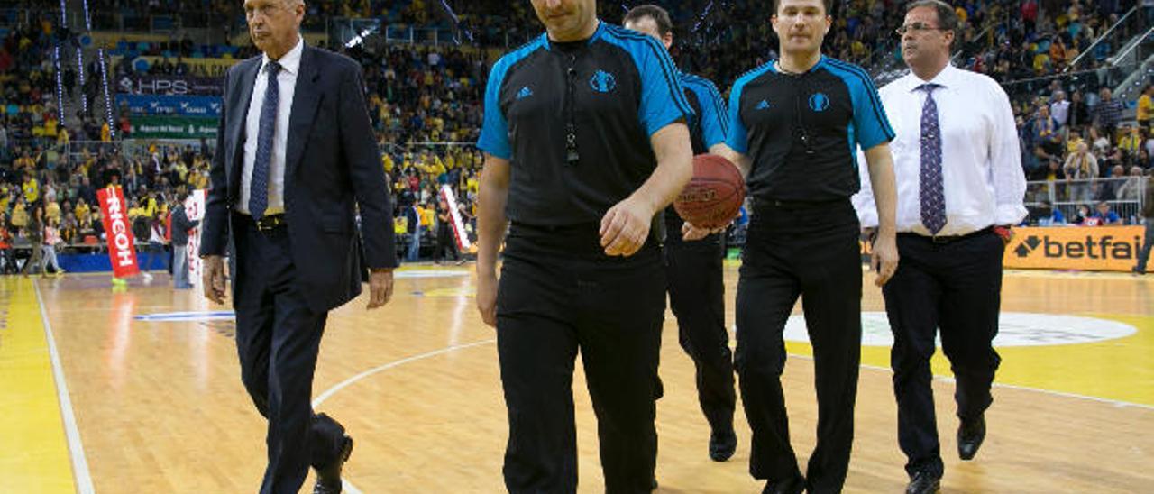 Retirada del equipo arbitral, en el parqué del Gran Canaria Arena, junto a Miguel Montes -i-.