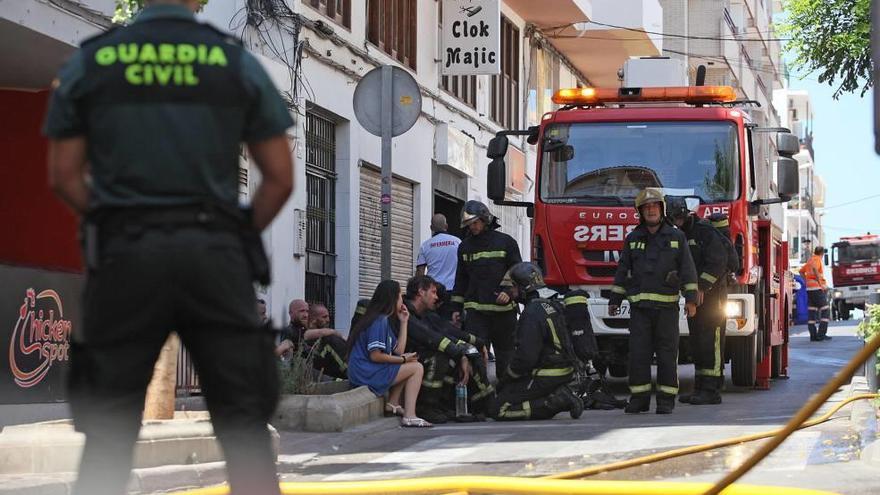 Los bomberos, junto con varios afectados en Sant Antoni.