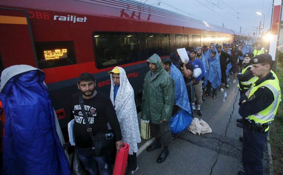 Refugiats arriben a l’estació de tren de Nickelsdorf, a Àustria, per pujar als combois cap a Alemanya, aquest dissabte