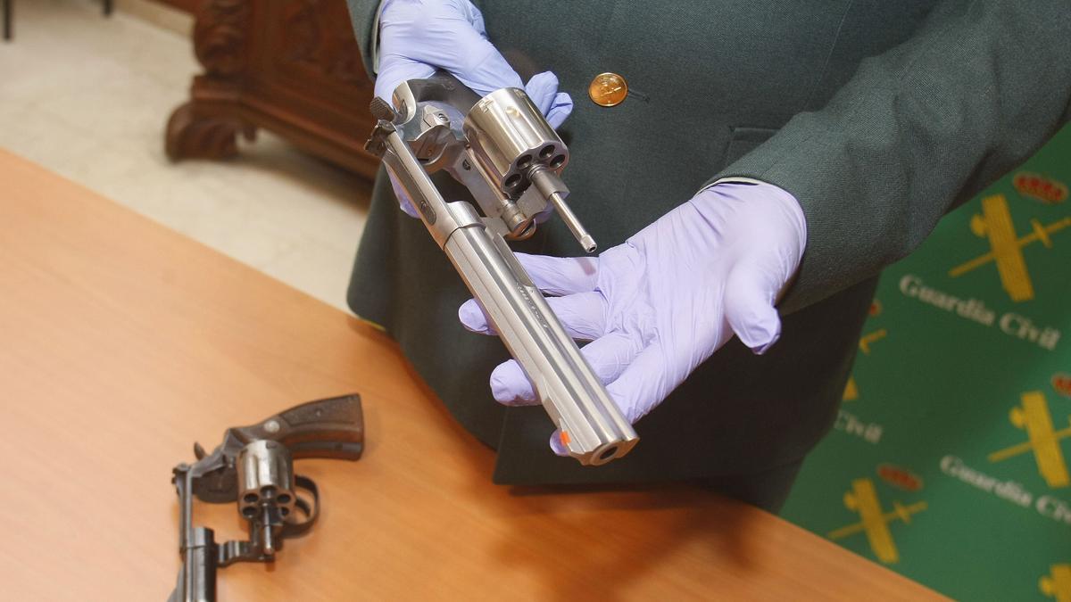 Un agente muestra el arma que empleaba el frutero atracador en sus golpes en Alicante y Murcia.