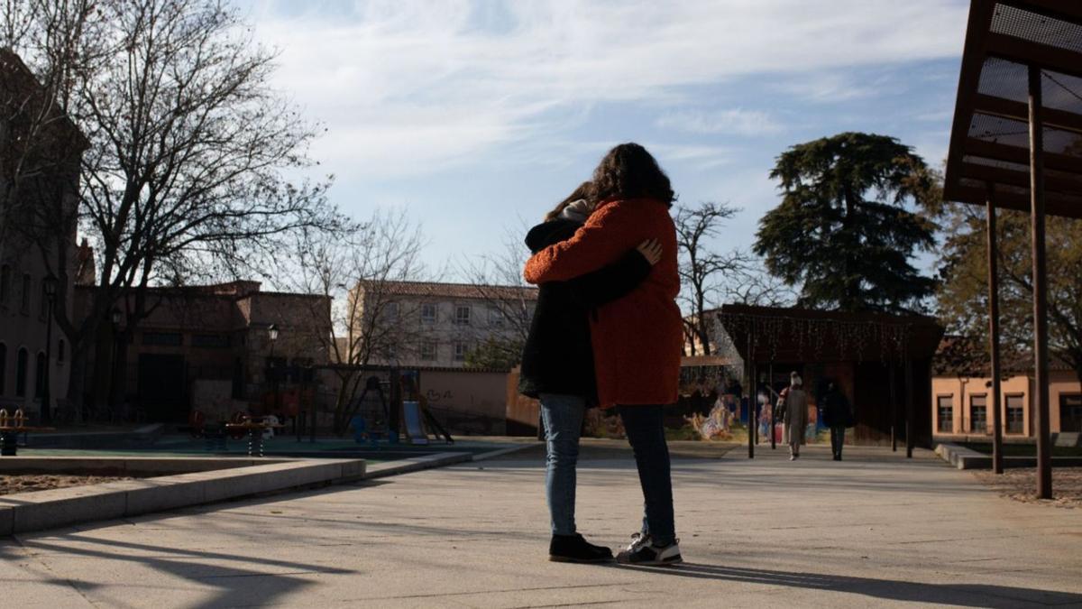 Dos mujeres se abrazan en un parque de Zamora.