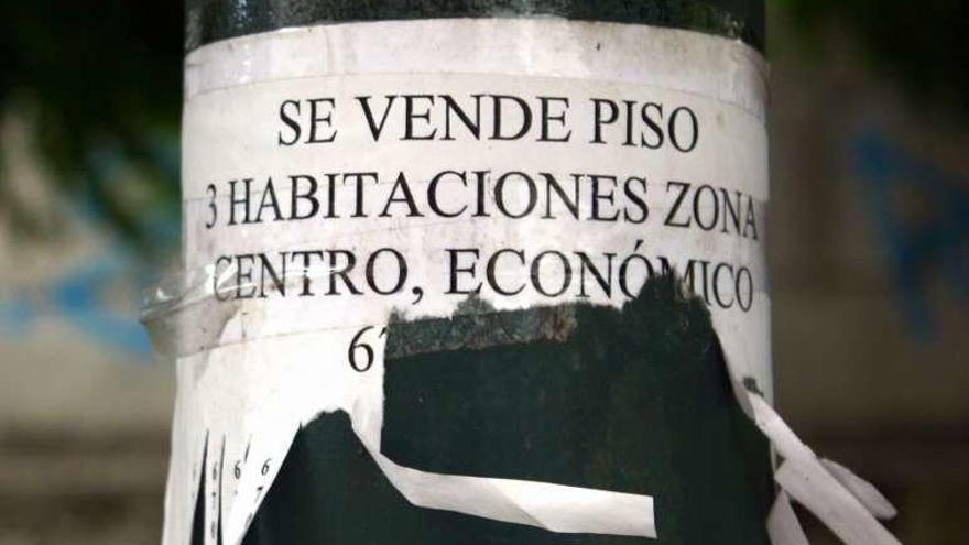 Cartel de venta de un piso en una farola.