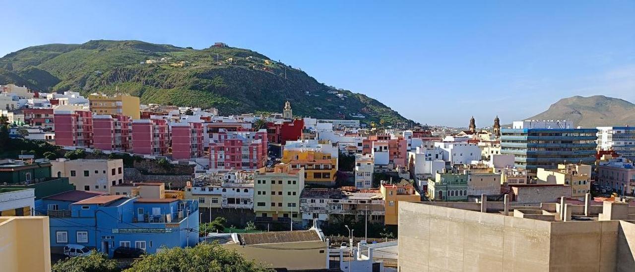 Vista de la trasera de las antiguas naves agrícolas, la ermita de San Sebastián y, al fondo, el casco de Guía, donde se actuará.