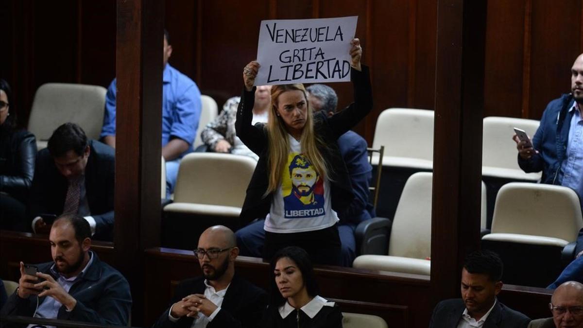 La activista Lilian Tintori, esposa del arrestado opositor venezolano Leopoldo López, muestra una pancarta contra Maduro en la Asamblea Nacional de Venezuela.