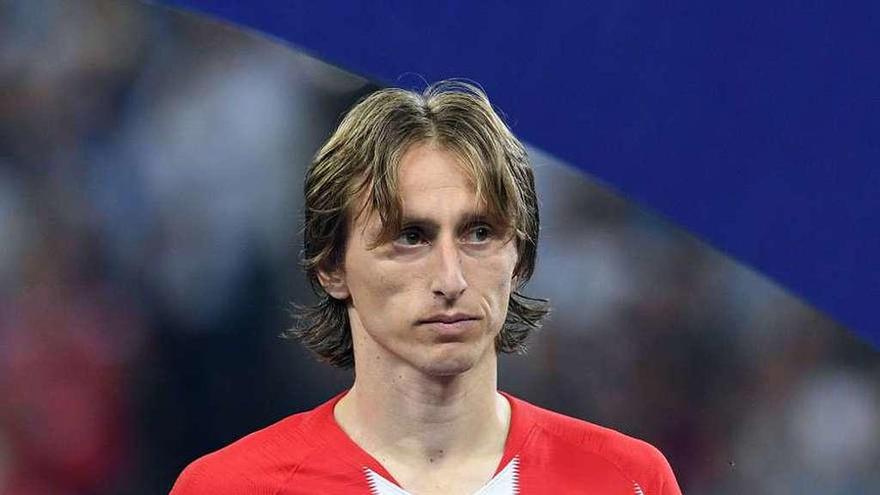 Luka Modric sostiene con aire triste el trofeo al mejor futbolista del Mundial de Rusia. // Efe
