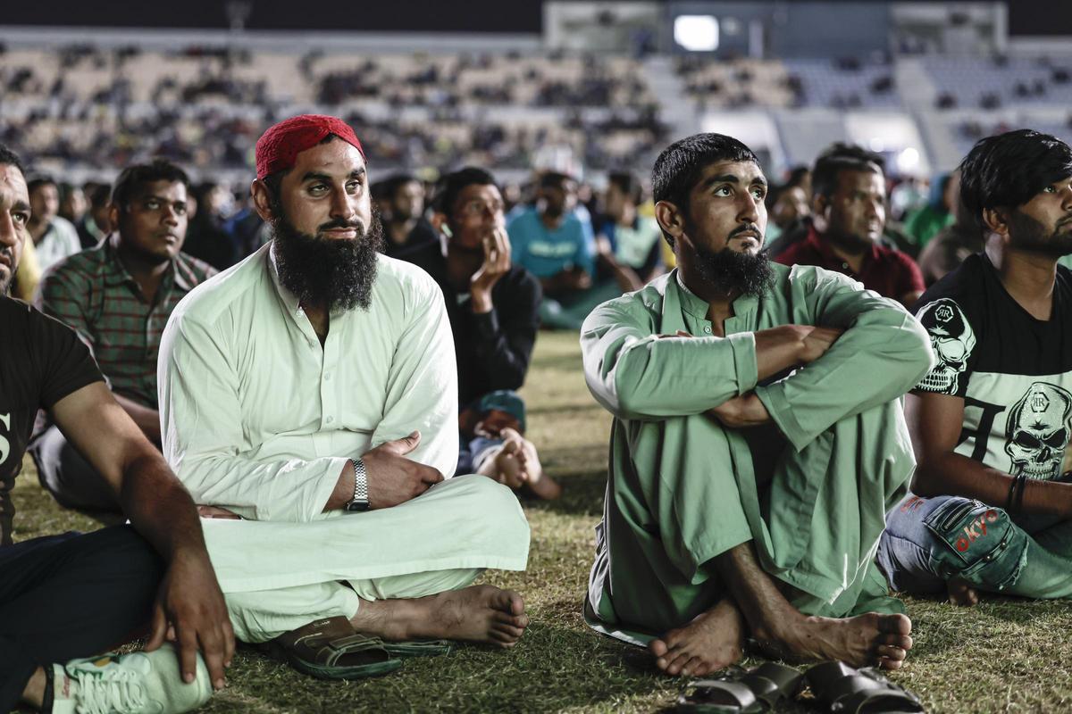 Trabajadores migrantes ven la retransmisisión del España - Alemania del Mundial de Qatar 2022.