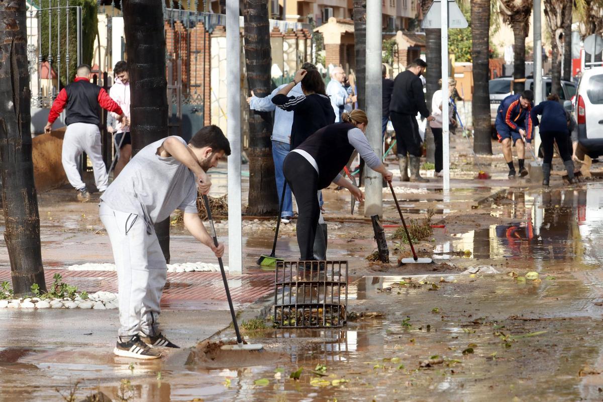 Vecinos de la barriada malaguena de Campanillas en 2020 limpiando las calles tras las inundaciones por el desbordamiento del río Campanillas