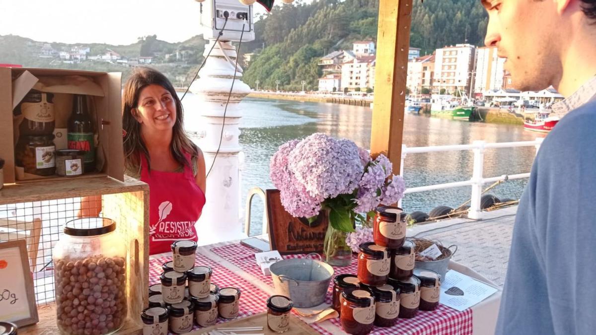 Alfonso Gil Ramos, veraneante madrileño, ante el puesto de crema ecológica de cacao de Silvia Catalán en el Mercado Ecológico de Ribadesella. | J.Q.