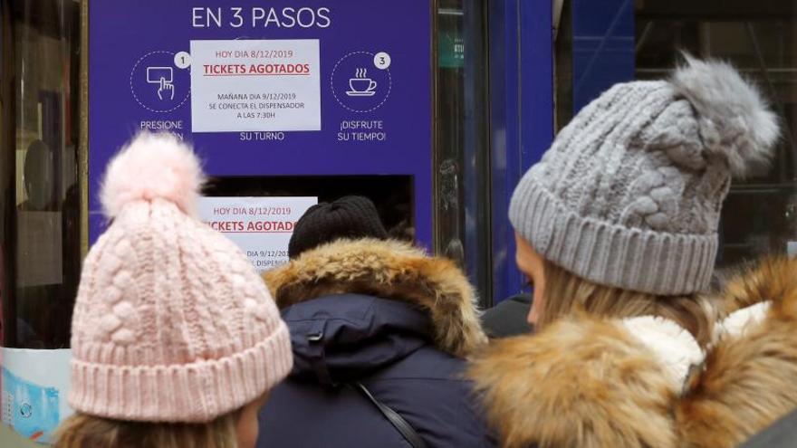 Un grupo de personas guarda cola para adquirir sus décimos de loteria.